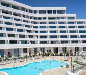 a large apartment building with a swimming pool and chairs at סי סייד אילת סוויטה משפחתית מפנקת 2 חדרים מרחק הליכה מהים in Eilat