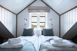 two beds in a room with a window at Kuringen Brygge Hotel and Restaurant in Refsnes