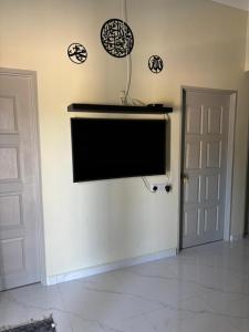 a flat screen tv on a wall in a room at Airisafiq Homestay in Kampong Sungai Rambai