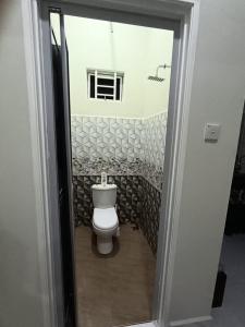 a bathroom with a white toilet in a room at Airisafiq Homestay in Kampong Sungai Rambai