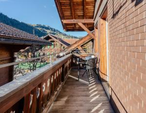 a balcony with a table and chairs on it at Central City Apartment 2 with Mountain View in Zweisimmen