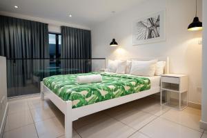 a bedroom with a bed with a green and white blanket at Oasis Apartments Gh by Embassy Gardens in Accra +34 photos