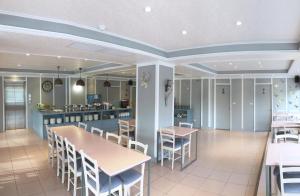 Un restaurante con mesas y sillas y una cocina. en Wan Tai Hotel, en Chiayi