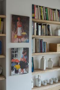 two paintings of a woman on a shelf with books at A Casa Di Ita in Villorba