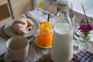 a table with a glass of milk and a plate of orange juice at A Casa Di Ita in Villorba