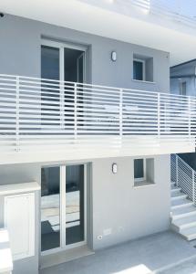 a white house with a balcony and stairs at Alba B&B in Cattolica