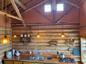 a kitchen with wooden walls and a sink and lights at Camping et Gîtes Brenazet in Vernusse