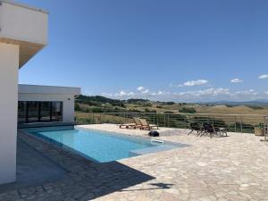 a house with a swimming pool and a patio with chairs at Villa Al Fianco in Petacciato