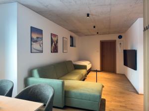 a living room with a couch and a tv at Apartmán Ore&Moor in Boží Dar