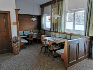a dining room with tables and chairs and windows at Privatzimmer Haus Lienbacher in Mittersill