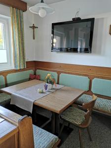 a dining room with two tables and a tv on the wall at Privatzimmer Haus Lienbacher in Mittersill