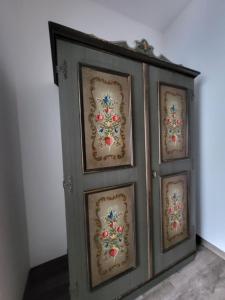 a gray cabinet with four paintings on it at Privatzimmer Haus Lienbacher in Mittersill