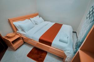 a small bedroom with a bed and a night stand at Cityscape And Retreat Hotel in Mbeya +29 photos