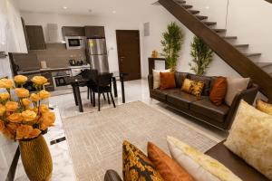 a living room with a couch and a kitchen at Oasis Apartments Gh by Embassy Gardens in Accra