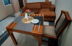 a wooden table and chair with a table and a couch at Cityscape And Retreat Hotel in Mbeya
