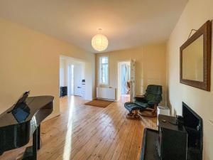 an empty living room with two chairs and a piano at Holly Croft in Drem