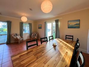 a dining room with a wooden table and chairs at Holly Croft in Drem