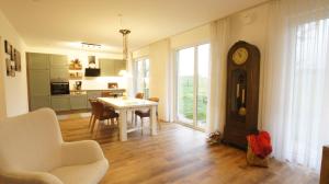 a living room with a table and a grandfather clock at Ferienhaus Sonne in Göhren-Lebbin