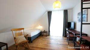 a bedroom with a bed and a desk and a chair at Ferienhaus Sonne in Göhren-Lebbin