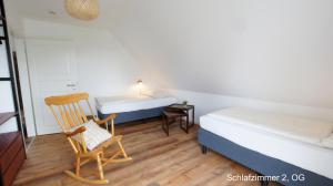 a bedroom with a bed and a chair and a desk at Ferienhaus Sonne in Göhren-Lebbin