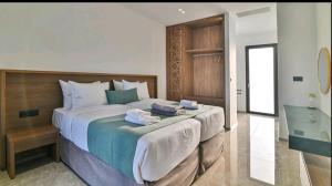 a bedroom with a large bed with towels on it at Palme Luxury Villa in Galatás +48 photos