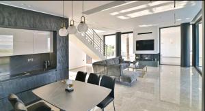 a kitchen and living room with a table and chairs at Palme Luxury Villa in Galatás