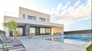 a house with a swimming pool in front of it at Palme Luxury Villa in Galatás