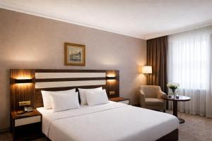 a hotel room with a large bed and a chair at Akgün Hotel Laleli Istanbul in Istanbul