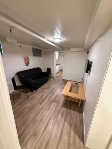 a living room with a black couch and a table at Tune Hotell Sarpsborg in Sarpsborg