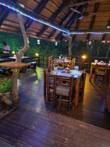 a restaurant with wooden tables and chairs and a tree at Jabula Kruger Safari Lodge in Marloth Park