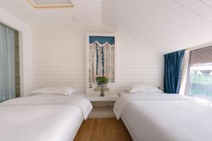 two beds in a room with a window at YISHUYIHUACoFFee Hotel in Zhangjiajie +15 photos