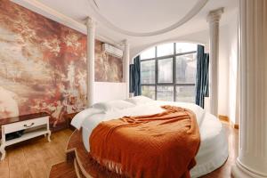 a bedroom with a large bed with a painting on the wall at YISHUYIHUACoFFee Hotel in Zhangjiajie