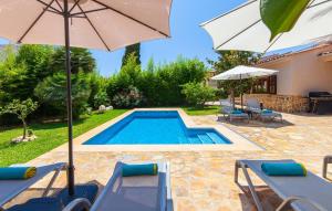 a pool with chairs and umbrellas next to a house at Mirte in Sa Coma