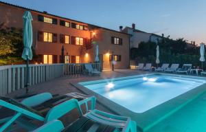 a large swimming pool with chairs and a building at Villa Vinkuran in Vinkuran