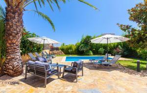 a group of chairs and umbrellas next to a pool at Mirte in Sa Coma +29 photos