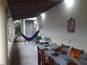 a dining room with a table and chairs and a hammock at Recanto do Cajueiro - Luís Correia - Piauí in Luis Correia