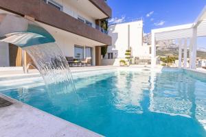 a swimming pool with a water fountain at Exlusive Villa M -Baska Voda in Baška Voda