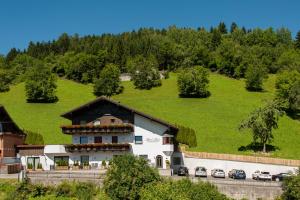 a white house with a black roof on a hill at Apart Josef in Ladis