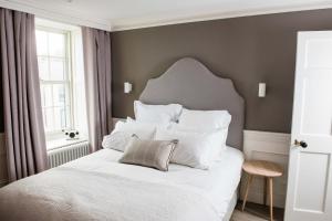 a bedroom with a white bed with a gray wall at One Shore Street in Donaghadee