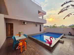 a house with a swimming pool with a table and chairs at ll EMPYREAN STAYS ll SUPREME VILLA II 3BHK II AC II PVT POOL II MINI BAR in Lonavala
