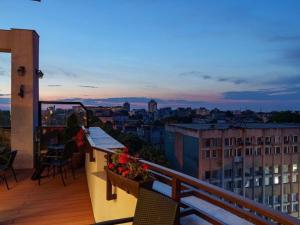 ein Balkon mit Blick auf die Stadt in der Abenddämmerung in der Unterkunft Guci Hotel in Constanţa