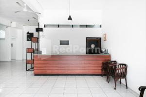 a lobby with a reception desk and two chairs at Katup Guest House Syariah Mitra RedDoorz in Yogyakarta