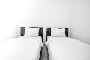 two beds sitting next to each other in a room at Katup Guest House Syariah Mitra RedDoorz in Yogyakarta +31 photos
