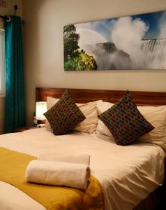 a bedroom with a large white bed with two pillows at Jollyboys Backpackers and Camp in Livingstone +10 photos