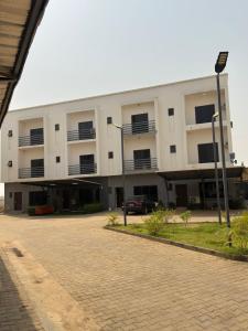 a white building with a car parked in front of it at EXQUISITE Home 2 Abuja in Abuja