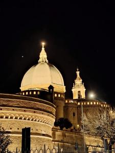 a large building with a domed roof at night at Casa Di Leonardo in Loreto +7 photos