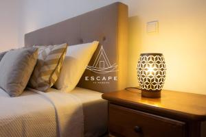a bedroom with a bed and a lamp on a night stand at Anavrin by Escape to Madeira in Ponta do Sol