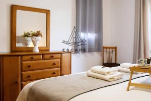 a bedroom with a bed with a dresser and a mirror at Anavrin by Escape to Madeira in Ponta do Sol