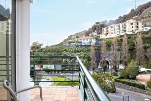 a balcony with a view of a river and buildings at Anavrin by Escape to Madeira in Ponta do Sol