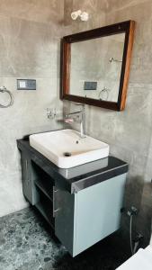 a bathroom with a sink and a mirror at Jameens Residence in Ambalangoda